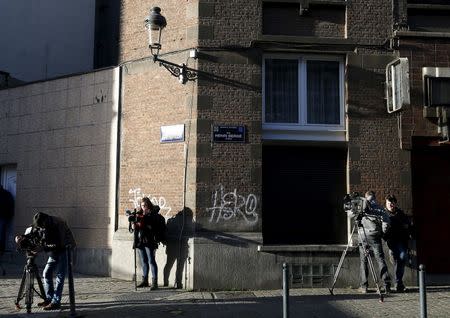 Reporters stand near a street sign which reads "Henri Berge" in the Brussels district of Schaerbeek, January 8, 2016. REUTERS/Francois Lenoir