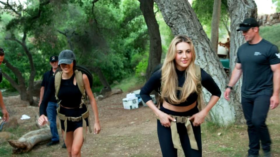 Sistine Stallone and Sophia Stallone with weights on their back in "The Family Stallone."