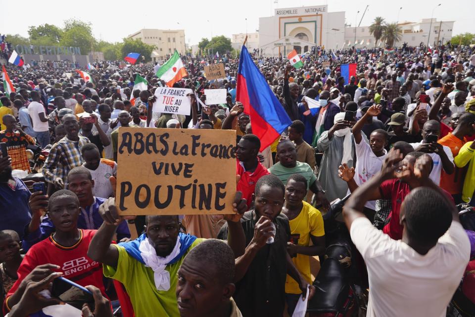 Nigeriens participate in a march called by supporters of coup leader Gen. Abdourahmane Tchiani in Niamey, Niger, Sunday, July 30, 2023. Days after mutinous soldiers ousted Niger's democratically elected president, uncertainty is mounting about the country's future and some are calling out the junta's reasons for seizing control. The sign reads: "Down with France, long live Putin." (AP Photo/Sam Mednick)