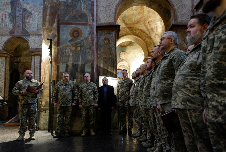 Ukrainian army chaplains attend a service during their graduation ceremony at St Sophia Cathedral in Kyiv on Friday (EPA)