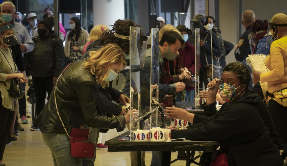 Voters sign in to cast votes at the Madison Square Garden's early voting polling site, Saturday Oct. 24, 2020, in New York. (AP Photo/Bebeto Matthews)