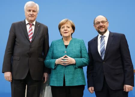 Christian Democratic Union (CDU) leader and German Chancellor Angela Merkel, Christian Social Union (CSU) leader Horst Seehofer and Social Democratic Party (SPD) leader Martin Schulz pose after a statement on coalition talks to form a new coalition government in Berlin, Germany, February 7, 2018. REUTERS/Axel Schmidt