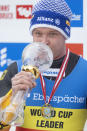 Felix Loch of Germany kisses the trophy after winning the Luge World Cup in Innsbruck, Austria, Saturday, Jan. 23, 2021. (AP Photo/Andreas Schaad)