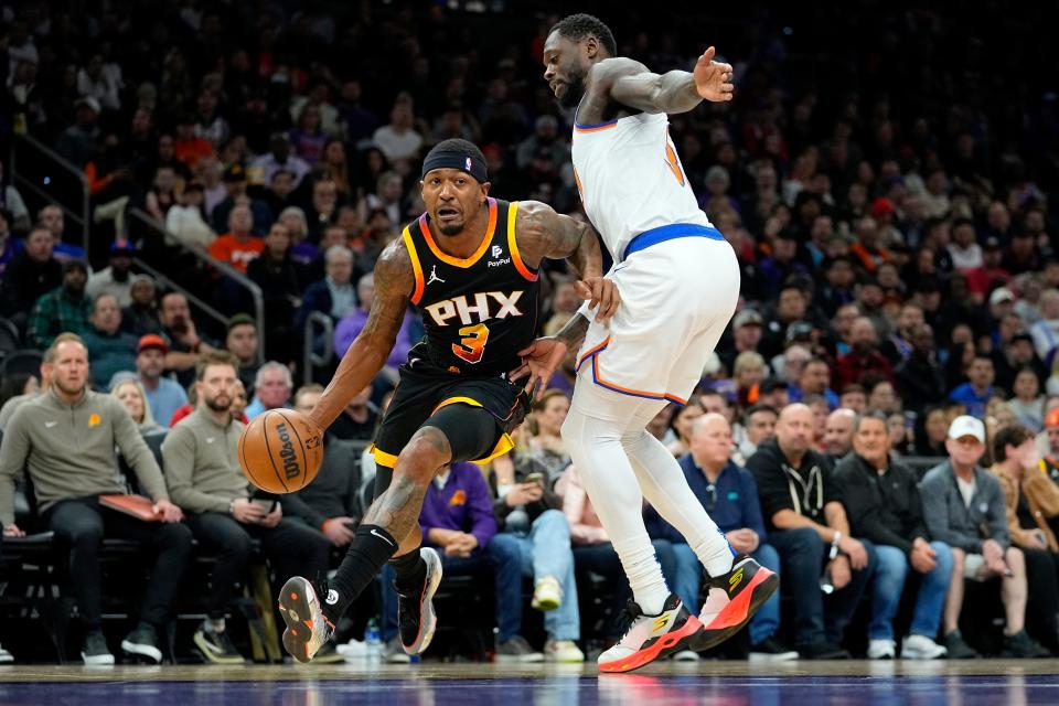 Phoenix Suns guard Bradley Beal (3) drives past New York Knicks forward Julius Randle during the first half of an NBA basketball game, Friday, Dec. 15, 2023, in Phoenix.