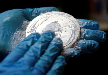 A worker from the Casa da Moeda do Brasil (Brazilian Mint) cleans a Rio 2016 Olympic medal in Rio de Janeiro, Brazil, June 28, 2016. REUTERS/Sergio Moraes