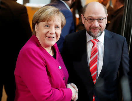 Leader of the Christian Democratic Union (CDU) and the acting German Chancellor Angela Merkel and Social Democratic Party (SPD) leader Martin Schulz shakes hands before exploratory talks about forming a new coalition government at the SPD headquarters in Berlin, Germany, January 7, 2018. REUTERS/Hannibal Hanschke