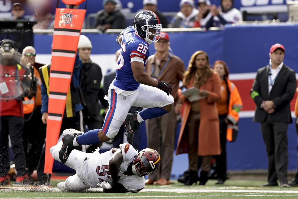 New York Giants running back Saquon Barkley (26) avoided a tackle by Washington Commanders linebacker Jamin Davis (52) during a touchdown run during the second quarter of an NFL football game, Sunday, Oct. 22, 2023, in East Rutherford, N.J. (AP Photo/Adam Hunger)