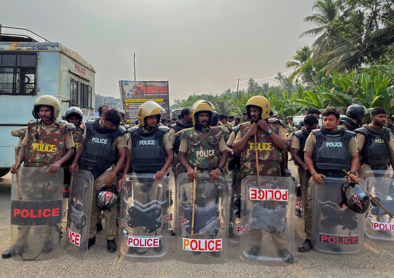 Policemen wearing riot gear stand at a protest site ahead of a rally by the supporters of the proposed Vizhinjam port project