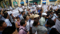 Demonstrators, holding signs to protest against Taiwanese enterprise Formosa Plastic and environmental-friendly messages, say they are demanding cleaner waters in the central regions after mass fish deaths in recent weeks, in Hanoi, Vietnam May 1, 2016. REUTERS/Kham