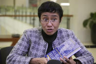 Journalist Maria Ressa, one of the winners of the 2021 Nobel Peace Prize, speaks while holding her book "How to Stand Up to a Dictator: The Fight for Our Future." during its launch, in metropolitan Manila, Philippines that coincides with International Human Rights Day, Saturday, Dec. 10, 2022. The co-founder of local news website Rappler faces a string of criminal charges filed by former President Rodrigo Duterte’s administration and his allies that are related to Rappler’s coverage of the killings in the war on drugs and alleged government-sponsored disinformation networks. (AP Photo/Aaron Favila)