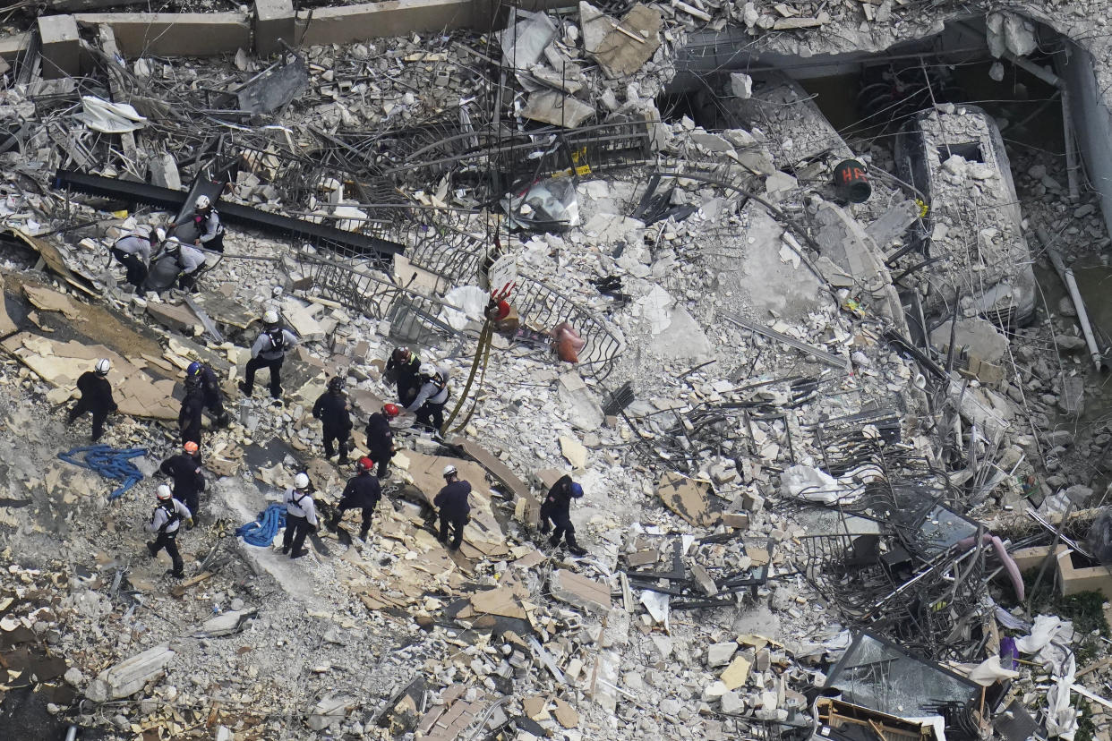 Image: Rescue workers search in the rubble at the Champlain Towers South Condo, in Surfside, Fla., on June 26, 2021. (Gerald Herbert / AP)