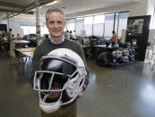 In this photo taken May 23, 2019, Dave Marver, CEO of VICIS, a Seattle-based company that makes football helmets, poses for a photo in Seattle as he holds one of the company's football helmets. VICIS announced on Monday, July 1, the cap is intended for use with youth flag football and the quickly expanding competitive 7-on-7 football played during the offseason for youth and high school programs. (AP Photo/Ted S. Warren)