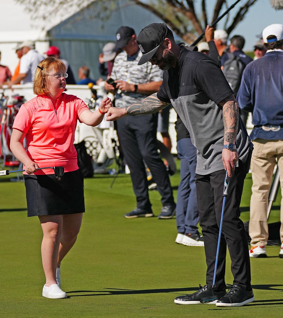 Amy Bockerstette, a Special Olympics athlete and local golf celebrity, celebrates a putt with State 48 founder Mike Spangenberg during the Celebrity Putt Challenge at the Waste Management Phoenix Open in Scottsdale on Tuesday, Feb. 8, 2022.