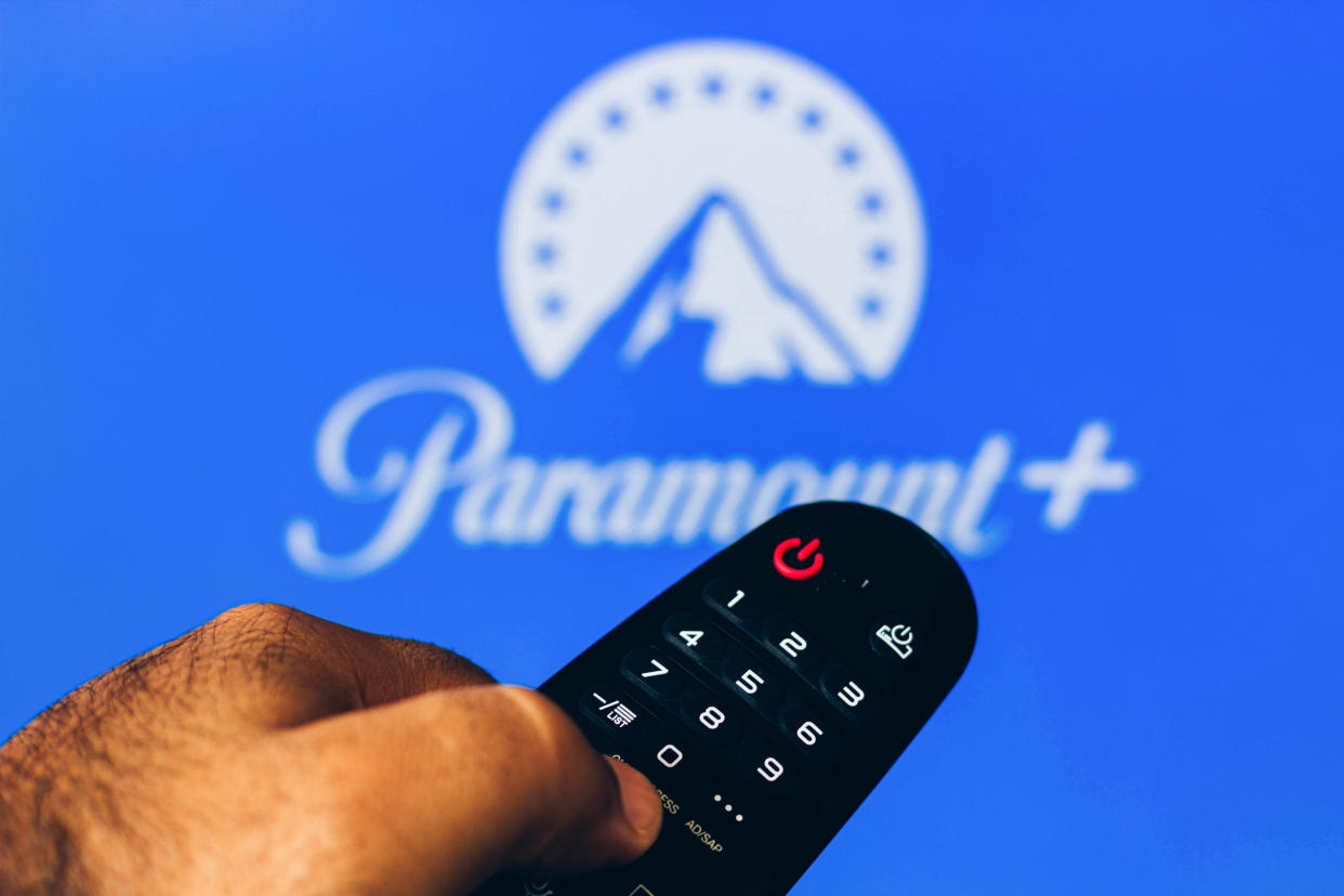 In this photo illustration, a hand holding a TV remote control points to a screen that displays the Paramount + (Plus) logo. (Photo Illustration by Rafael Henrique/SOPA Images/LightRocket via Getty Images)