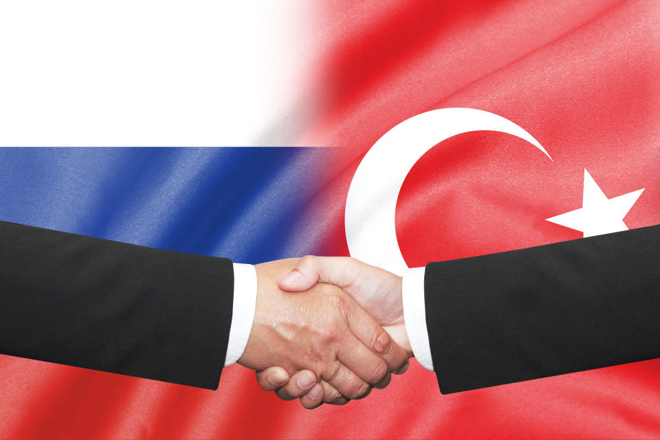 isolated two businessman shakehand over russia and turkey flag