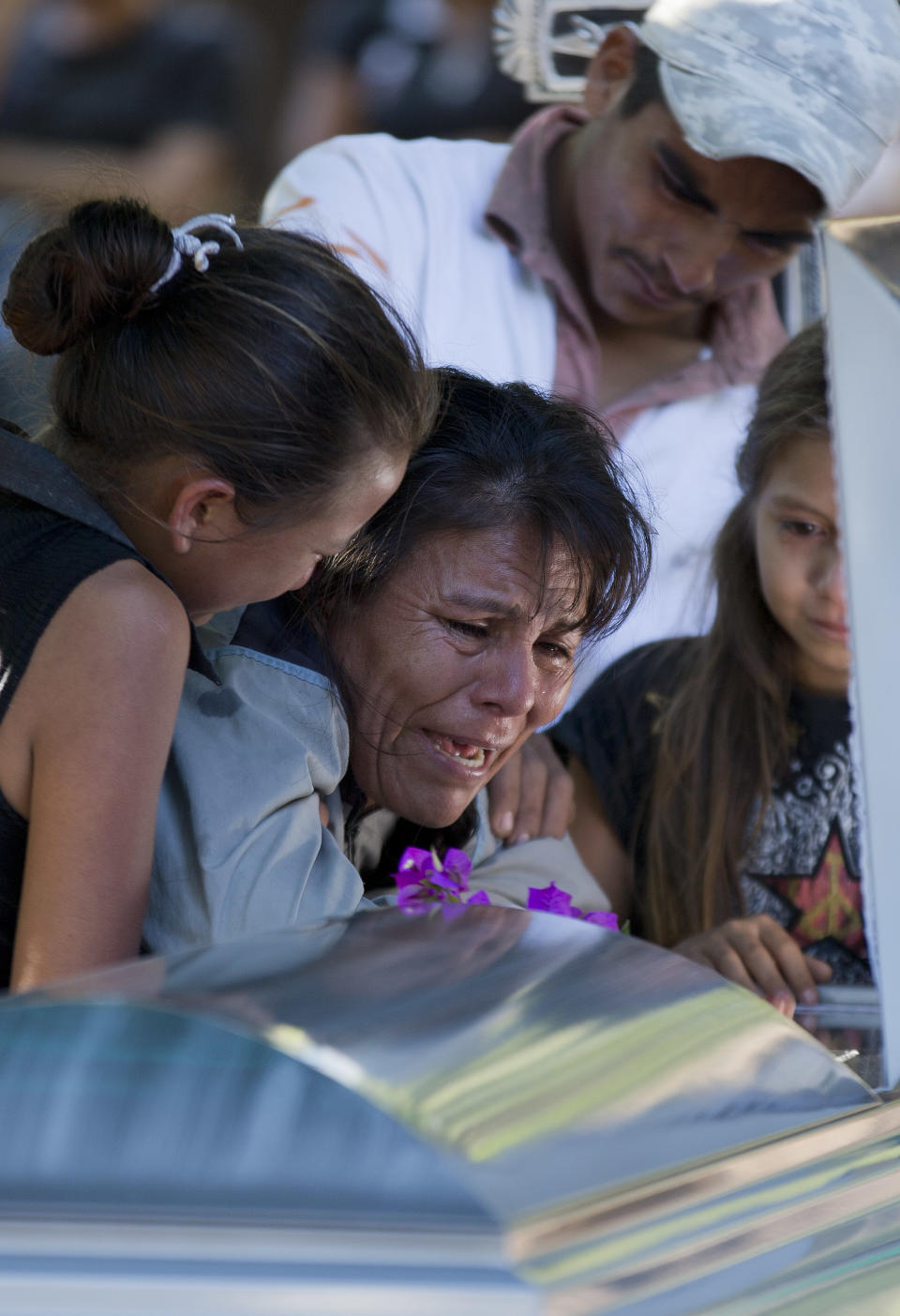 ADDS CIRCUMSTANCE OF DEATH - Juana Perez cries beside the coffin of her son Rodrigo Benitez, 25, killed in the recent fighting in Antunez, Mexico, Tuesday, Jan. 14, 2014. The government moved in to quell violence between vigilantes and a drug cartel, and witnesses say several unarmed civilians were killed in an early Tuesday confrontation. According to family members at the funeral, Benitez died in the crossfire between self-defense members and soldiers after he and other townspeople were called to meet a convoy of soldiers who they were told were coming to disarm the self-defense group. (AP Photo/Eduardo Verdugo)