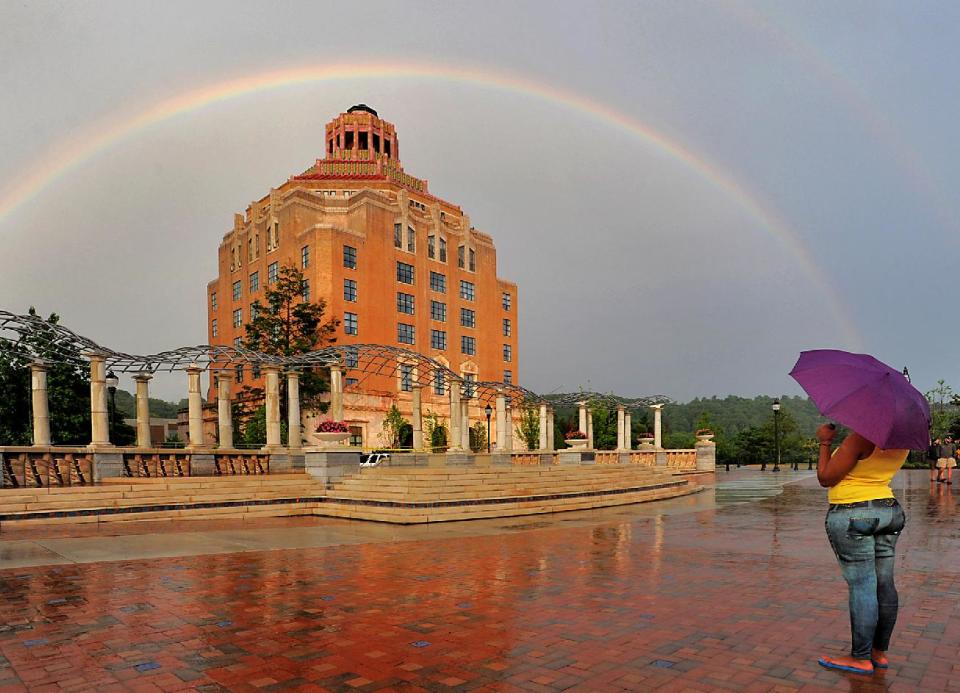 FILE - In this June 16, 2010 file photo, a rainbow forms over the City Hall building in Asheville, N.C. The idea of people who uproot and move when they retire conjures up images of warm, sunny Florida or Arizona. But some of the older members of the baby boom generation (the 78 million Americans born between 1946 and 1964) are looking elsewhere, and a number of towns in cooler climates from Maine to Washington have become popular retirement destinations. Asheville has also merited mention in the lists of best places for retirees. (AP Photo/Asheville Citizen-Times, John Coutlakis, File) NO SALES