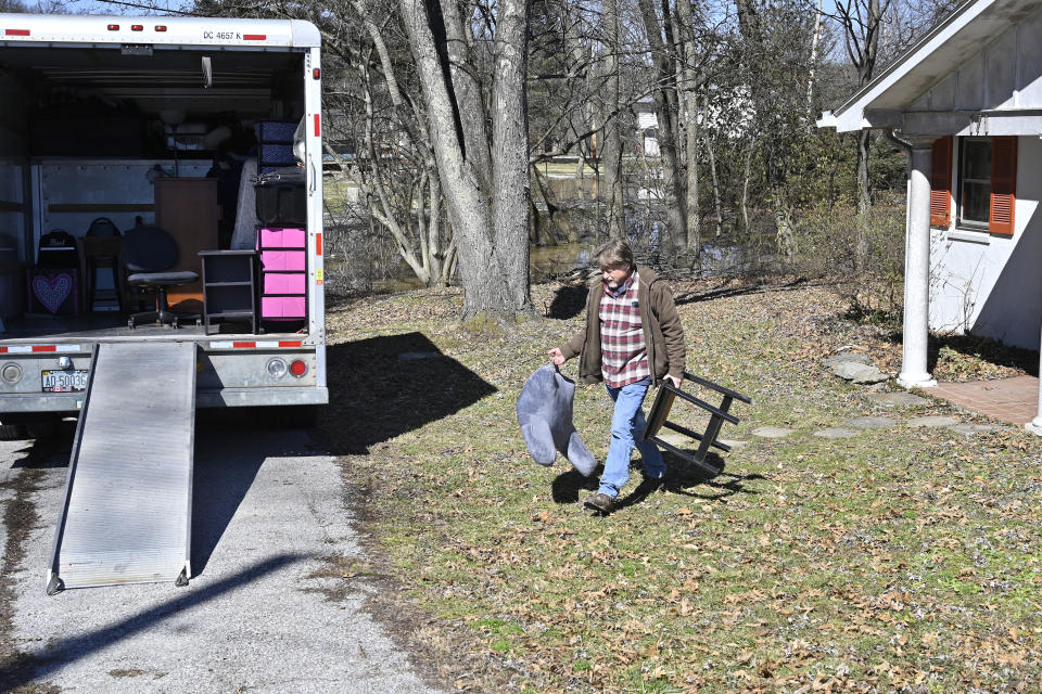 Ray Smith helps to move the furniture from the home of his friend Kelly Sparrow as the rising Kentucky River inches closer Tuesday, March 2, 2021, in Frankfort, Ky. (AP Photo/Timothy D. Easley)