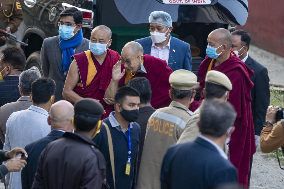 Tibetan spiritual leader the Dalai Lama removes his face mask to greet a member in the crowd as he arrives at the Zonal Hospital to receive a COVID-19 vaccine in Dharmsala, India, Saturday, March 6, 2021. Medical officers confirmed that the Tibetan leader got the Covishield vaccine and is not showing any adverse reaction to the vaccine. (AP Photo/Ashwini Bhatia)