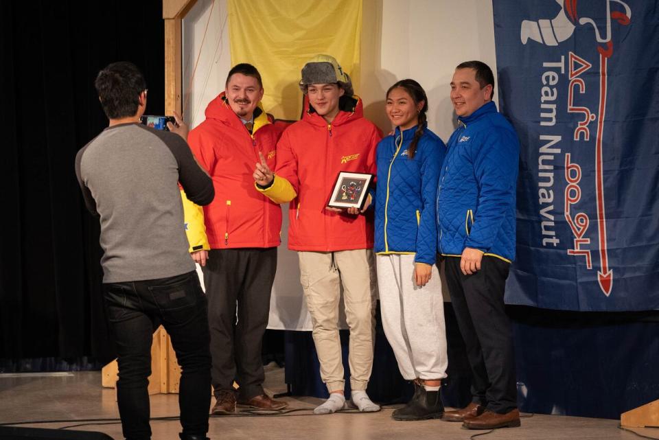 Team Nunavut athletes pose with Premier P.J. Akeeagok at the unveiling of the 2024 Arctic Winter Games uniforms. 