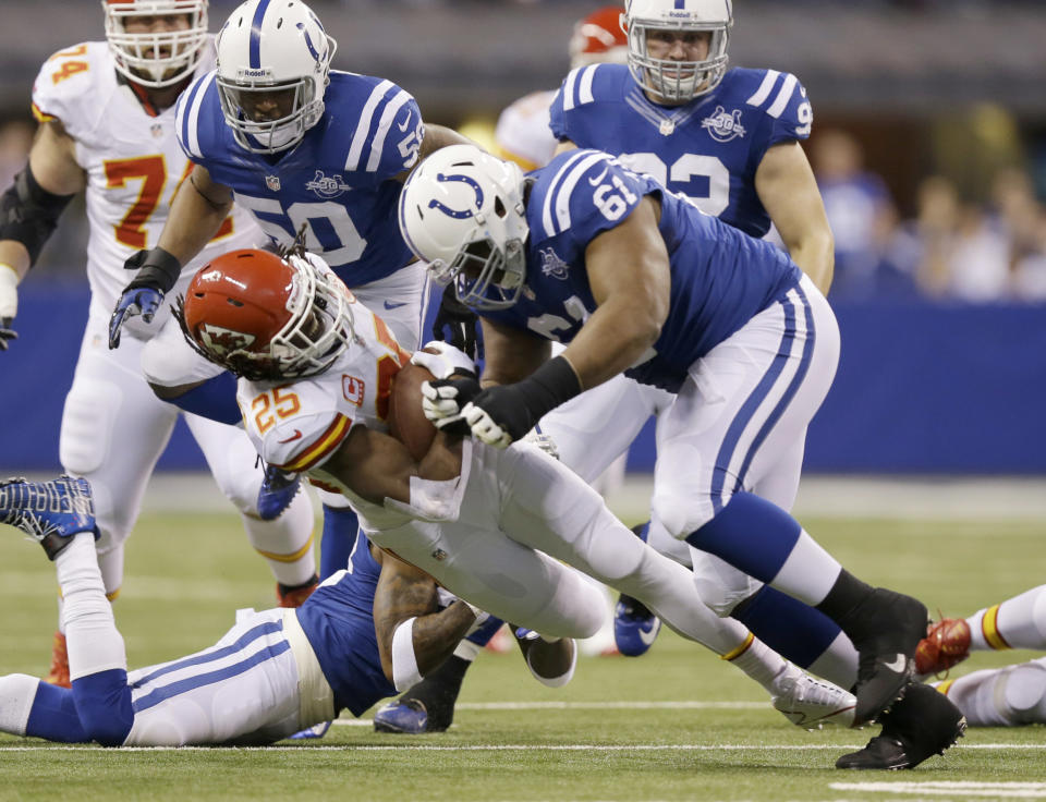 Kansas City Chiefs running back Jamaal Charles (25) is tackled by Indianapolis Colts defensive tackle Jeris Pendleton (61) during the first half of an NFL wild-card playoff football game Saturday, Jan. 4, 2014, in Indianapolis. (AP Photo/Michael Conroy)