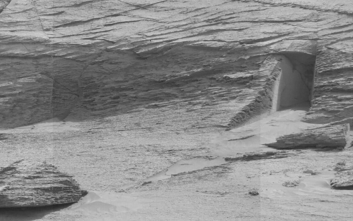 Grainy image shows what appears to be a carved-out doorway on the side of the rock face on Mars - NASA/JPL-Caltech/MSSS/SWNS 