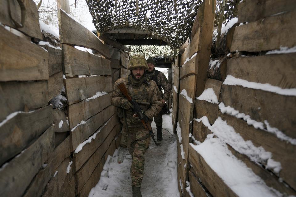 Ukrainian servicemen walk in a trench on the front line in the Luhansk region, eastern Ukraine, Friday, Jan. 28, 2022. High-stakes diplomacy continued on Friday in a bid to avert a war in Eastern Europe. The urgent efforts come as 100,000 Russian troops are massed near Ukraine's border and the Biden administration worries that Russian President Vladimir Putin will mount some sort of invasion within weeks. (AP Photo/Vadim Ghirda)