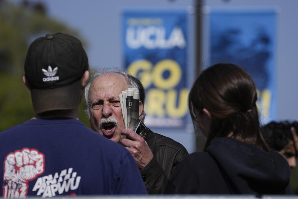 Two people argue opposing views near the site of a pro-Palestinian encampment, which was cleared overnight by police, on the UCLA campus Thursday, May 2, 2024, in Los Angeles. (AP Photo/Mark J. Terrill)