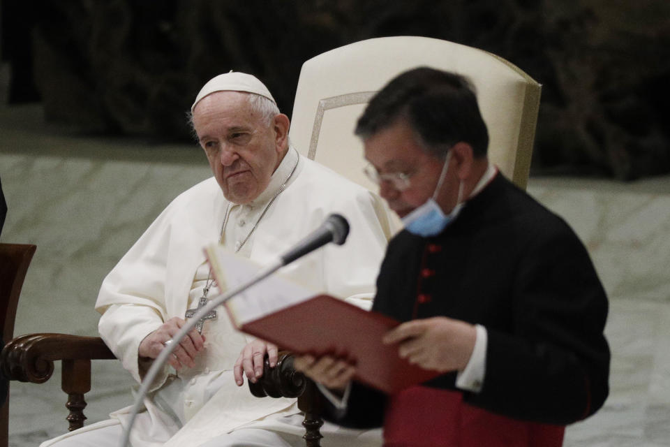 Pope Francis listens to a priests introducing the group of faithful attending the weekly general audience in the Paul VI hall at the Vatican, Wednesday, Oct. 21, 2020. (AP Photo/Gregorio Borgia)