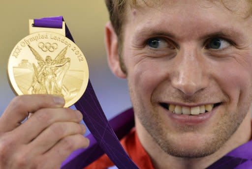 Britain's Jason Kenny poses on the podium after winning the gold medal in the London 2012 Olympic Games men's sprint final cycling event at the Velodrome in the Olympic Park in East London