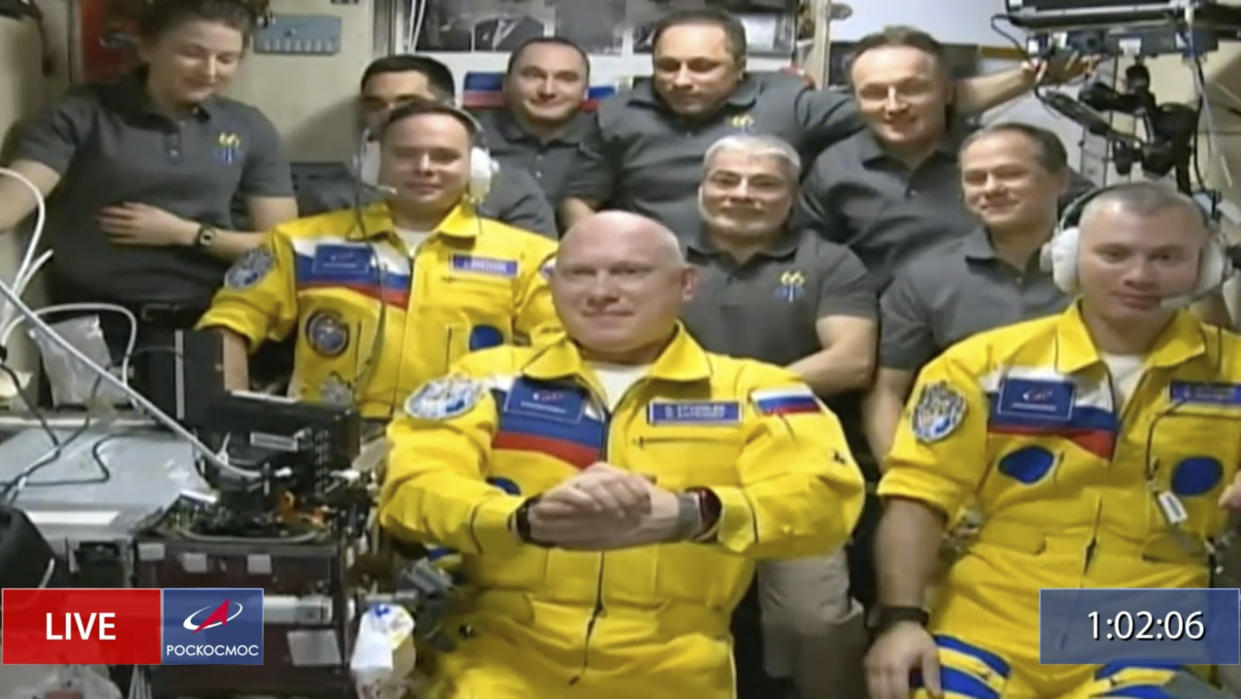 In this frame grab from video provided by Roscosmos, Russian cosmonauts Sergey Korsakov, Oleg Artemyev and Denis Matveyev are seen during a welcome ceremony after arriving at the International Space Station, Friday, March 18, 2022, the first new faces in space since the start of Russia’s war in Ukraine. The crew emerged from the Soyuz capsule wearing yellow flight suits with blue stripes, the colors of the Ukrainian flag. (Roscosmos via AP)