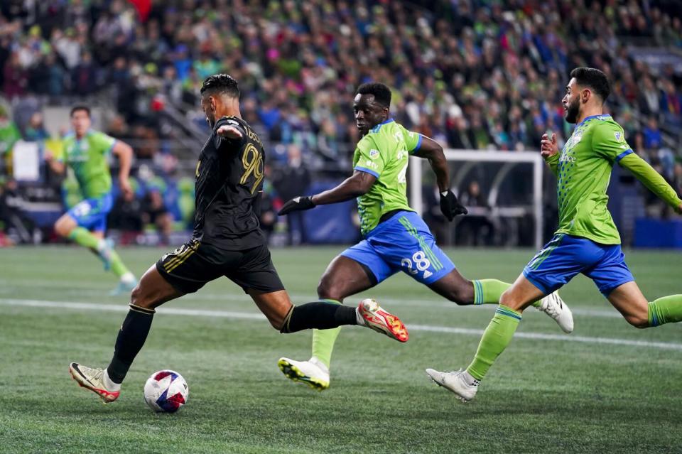 LAFC forward Denis Bouanga, left, winds back his right leg before scoring against Seattle on Sunday.