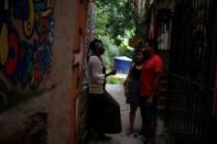 Solange, a worker at Pousada Favelinha hostel, talks to guests outside the hostel in Pereira da Silva favela, in Rio de Janeiro, Brazil, April 29, 2016. REUTERS/Pilar Olivares