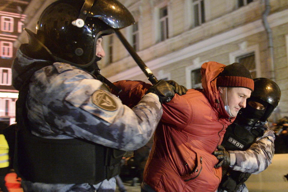 Police officers detain a Navalny supporter at the Red Square in Moscow, Russia, Tuesday, Feb. 2, 2021. A Moscow court has ordered Russian opposition leader Alexei Navalny to prison for more than 2 1/2 years on charges that he violated the terms of his probation while he was recuperating in Germany from nerve-agent poisoning. Navalny, who is the most prominent critic of President Vladimir Putin, had earlier denounced the proceedings as a vain attempt by the Kremlin to scare millions of Russians into submission. (AP Photo/Denis Kaminev)