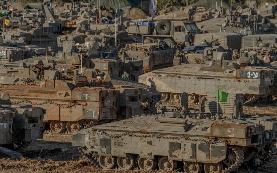 Israeli tanks and troop carriers gather near the Lebanese border