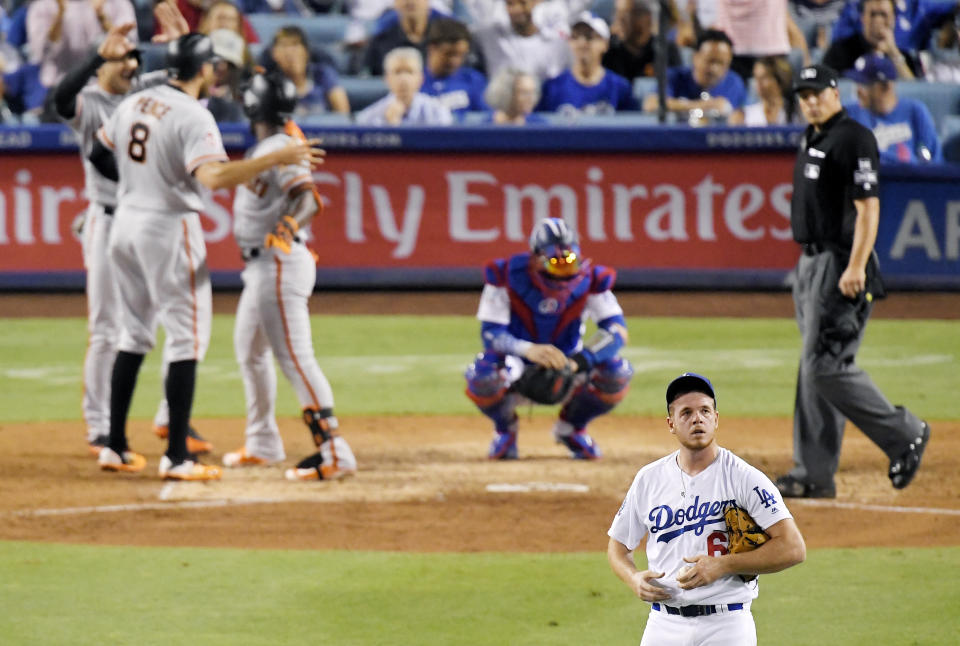 San Francisco Giants' Andrew McCutchen, third from right, celebrates with Chase d'Arnaud, left, and Hunter Pence after hitting a three-run home run off Los Angeles Dodgers starting pitcher Caleb Ferguson, foreground, during the eighth inning of a baseball game Wednesday, Aug. 15, 2018, in Los Angeles. (AP Photo/Mark J. Terrill)