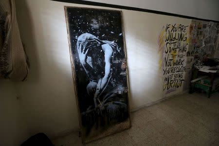 The doorway of a destroyed house, which was painted by British street artist Banksy, is seen inside the gallery of a local Palestinian artist after he bought it from the house's owner, in Khan Younis in the southern Gaza Strip April 1, 2015. REUTERS/Ibraheem Abu Mustafa