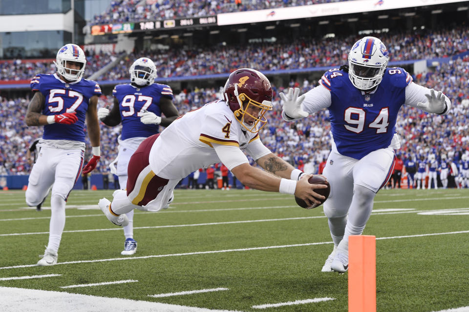 Washington Football Team quarterback Taylor Heinicke (4) dives past Buffalo Bills' Vernon Butler (94) for a touchdown as Bills' A.J. Epenesa (57) and Mario Addison (97) watch during the first half of an NFL football game Sunday, Sept. 26, 2021, in Orchard Park, N.Y. (AP Photo/Adrian Kraus)