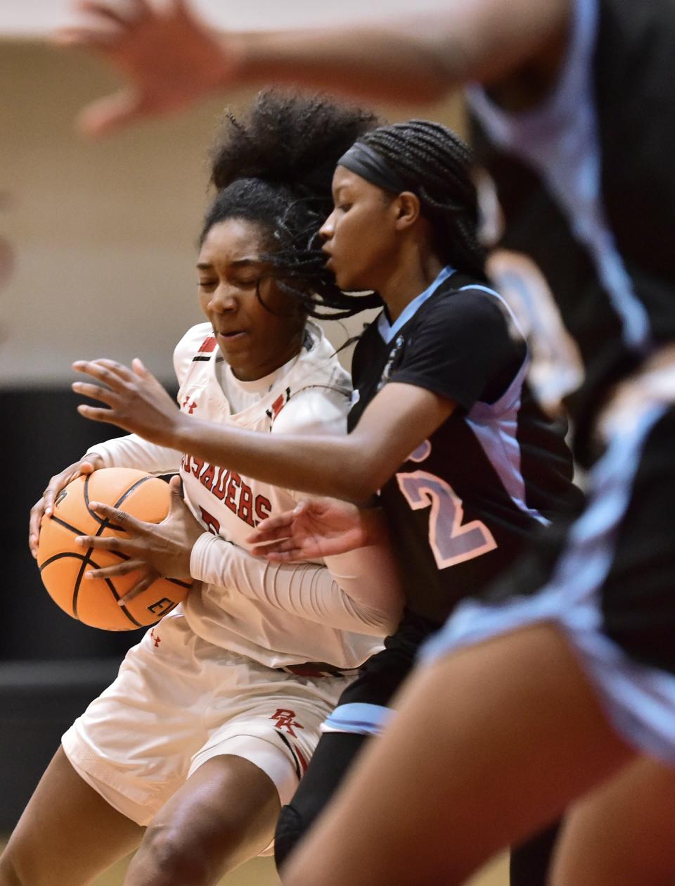 Bishop Kenny's Sydney Roundtree (5) and Ribault's Kayla Massey (2) make contact on a drive toward the basket in the playoffs in February 2023. The schools could meet again in this year's FHSAA girls basketball regionals.