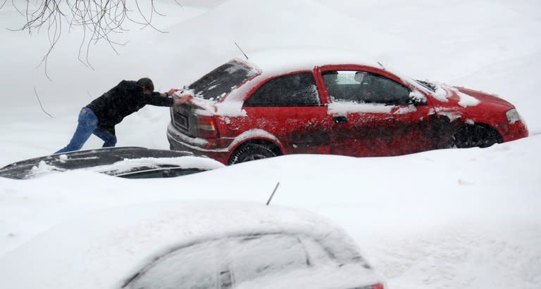 A man pushes a jammed car as heavy snow falls in Moscow, on March 15, 2013. Millions of people in northern Europe are still battling snow and ice, wondering why they are being punished with bitter cold when -- officially -- spring has arrived and Earth is in the grip of global warming