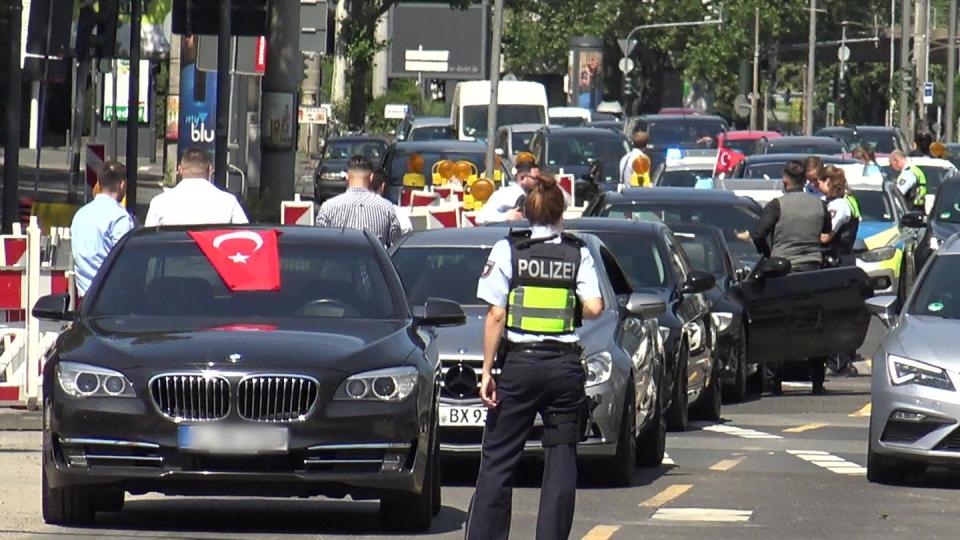 Eine Polizistin steht in Köln vor einem türkischen Hochzeitskorso - einer von dreien, den die Polizei in der Rheinmetropole am Wochenende angehalten hat. Foto: Thomas Kraus