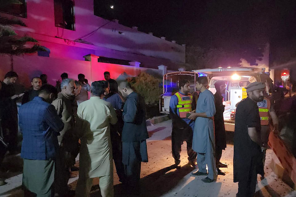 Plainclothes police officers and rescue workers gather close to the site of a bomb explosion, in Kabal, an area of Pakistan's Swat Valley, Monday, April 24, 2023. Two explosions Monday at a counterterrorism police facility in northwest Pakistan killed few people and wounded dozens, police said. (AP Photo/Sherin Zara)