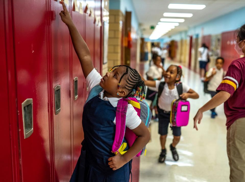 Foreign Language Immersion and Cultural Studies School first grader Mecca Arnold, left, finds her name for her locker during the first day of school at F.L.I.C.S. in Detroit on August 29, 2022.