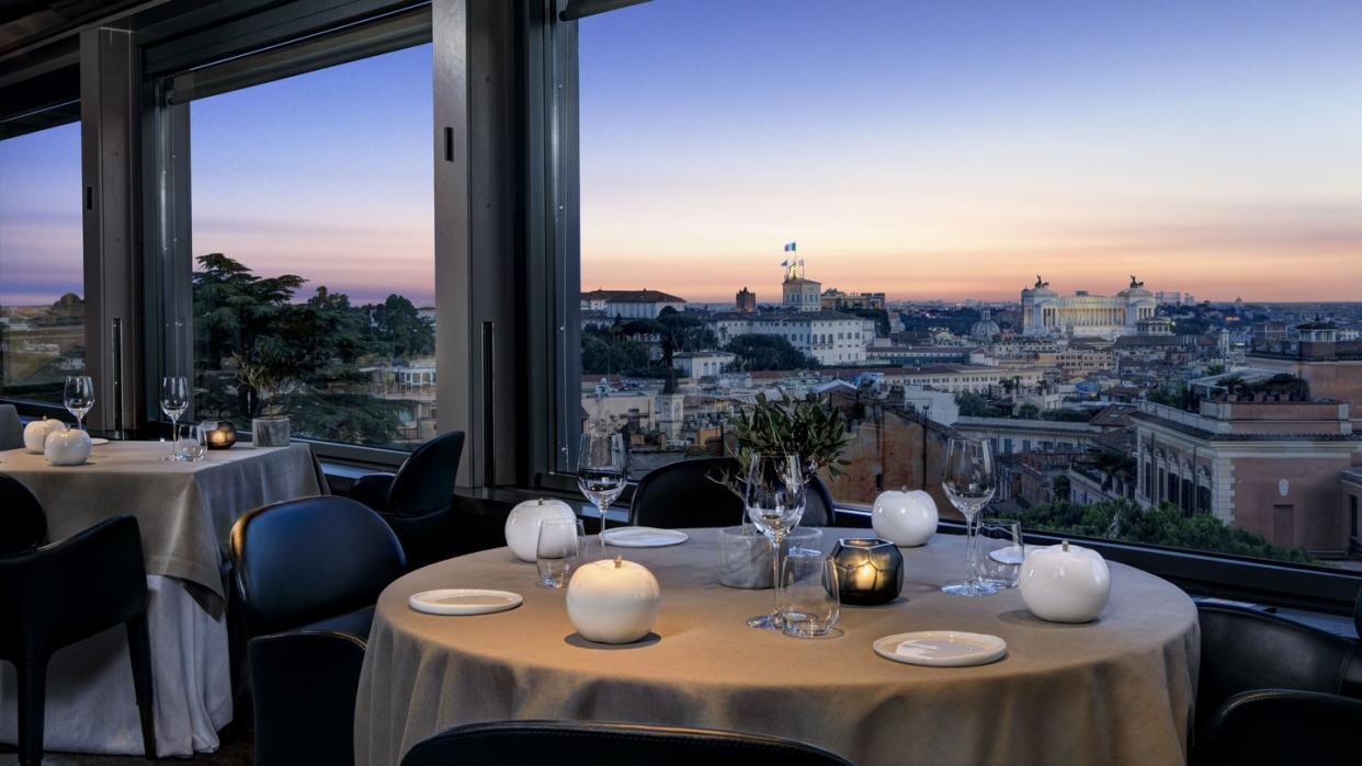 a table with plates and glasses on it with a view of a city