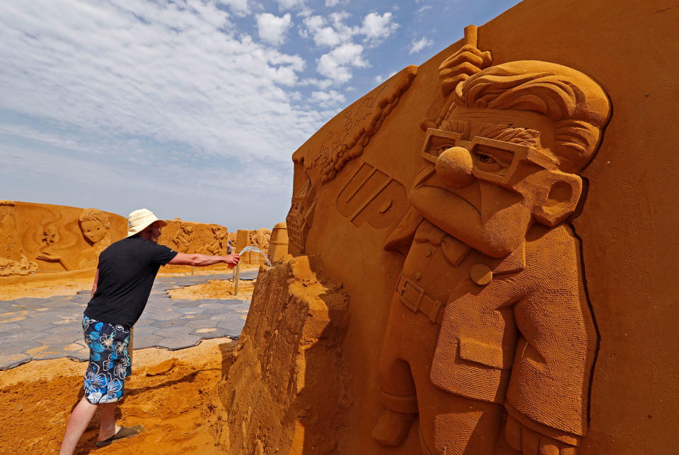 <p>Sand carver Teimur Abdul Ganiev from Russia works on a sculpture during the Sand Sculpture Festival “Disney Sand Magic” in Ostend, Belgium June 22, 2017. (Yves Herman/Reuters) </p>