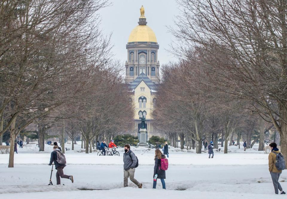 Students cross Notre Dame's campus between classes on Monday, Feb. 22, 2021, in South Bend.