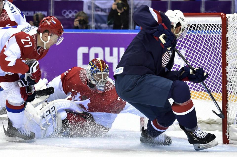 United States defenseman Cam Fowler, right, scores past Russia goalie Sergei Bobrovski, centre, as Russia forward Alexei Tereshenko, left, looks on during second period preliminary round hockey action at the 2014 Sochi Winter Olympics in Sochi, Russia on Saturday, Feb. 15, 2014. (AP Photo/The Canadian Press, Nathan Denette)