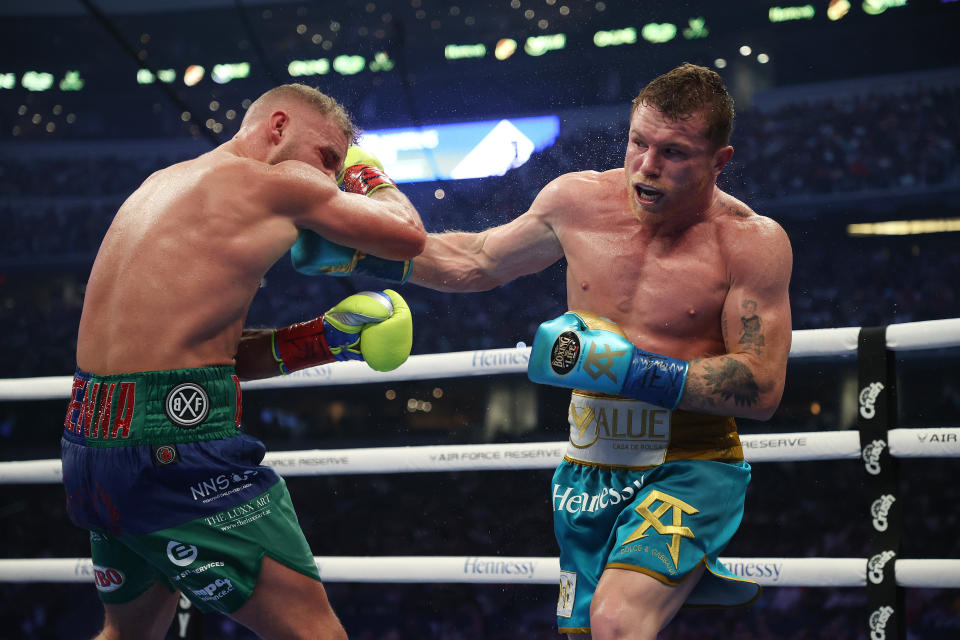 ARLINGTON, TEXAS - MAY 08:  Canelo Alvarez punches Billy Joe Saunders during their fight for Alvarez's WBC and WBA super middleweight titles and Saunders' WBO super middleweight title at AT&T Stadium on May 08, 2021 in Arlington, Texas. (Photo by Al Bello/Getty Images)