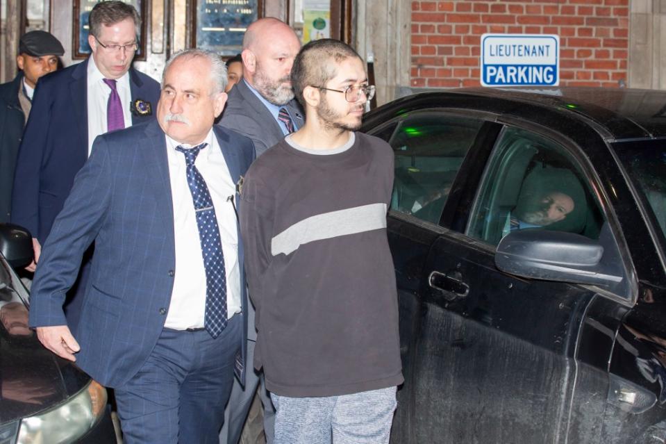 Police officers are seen escorting Justin Herde out of the precinct after he was charged with the murder of William Alvarez on a Bronx D train. William Miller