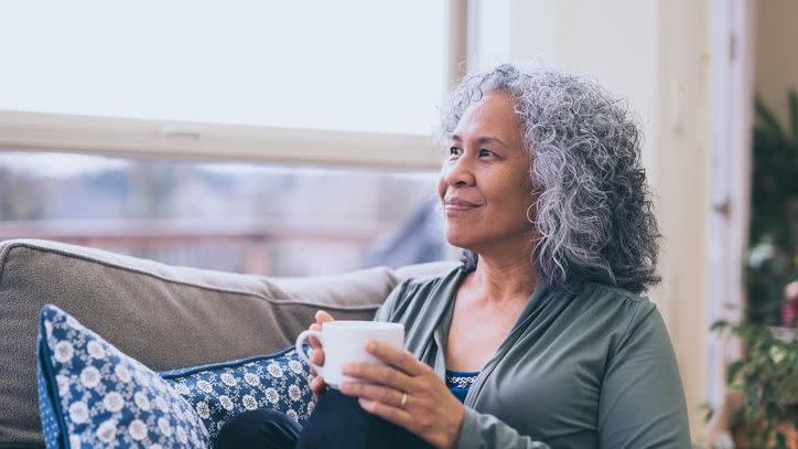 A retired woman enjoys a cup of coffee after working on her finances. 